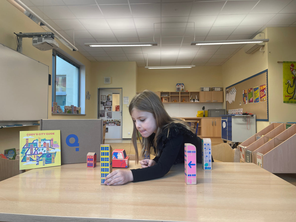 Girl playing with Cody Block in elementary school classroom